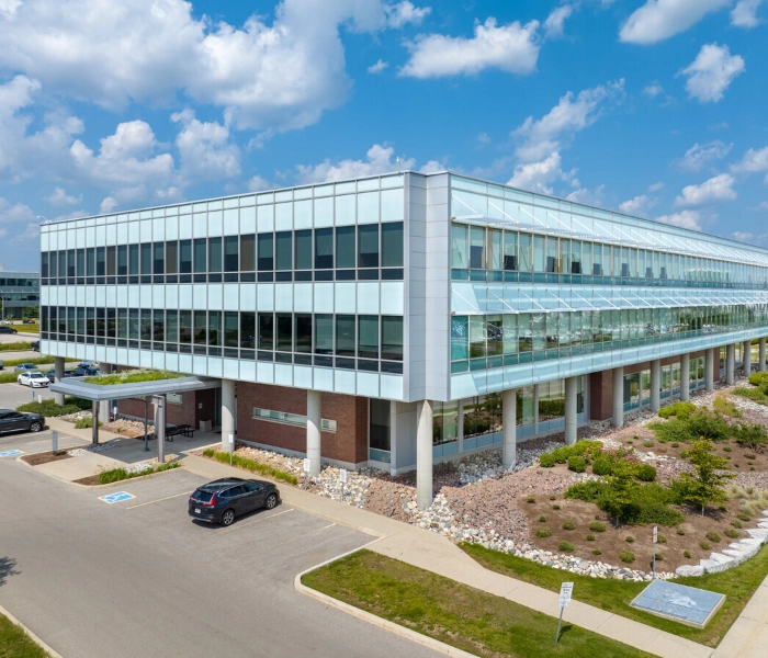 A modern glass office building on a clear summer day