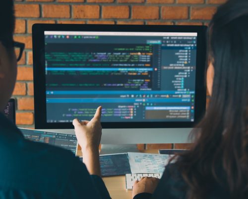 Developing programming and coding technologies working in a software engineers developing applications together in office.