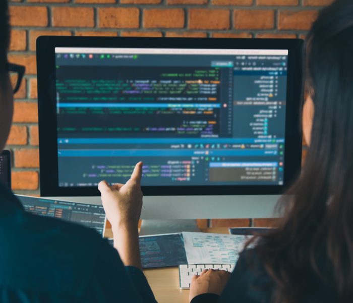 Developing programming and coding technologies working in a software engineers developing applications together in office.