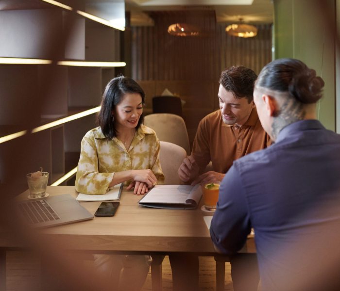 Positive business team meeting in restaurant to discuss contract terms