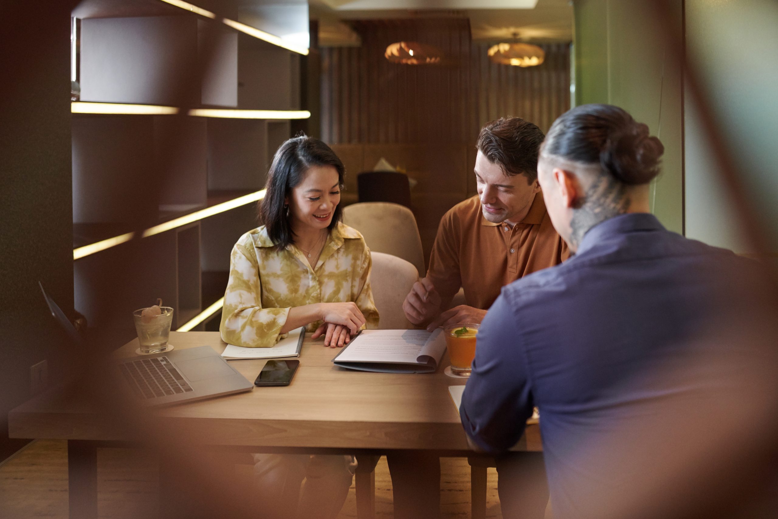 Three business owners talking through a service plan together across a table